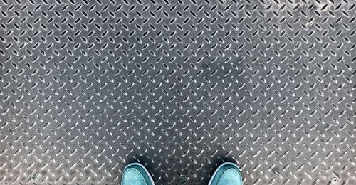 Low section of man standing on metal