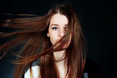 Portrait of young woman with hair in face