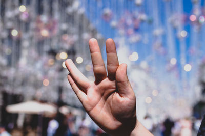 Close-up of human hand gesturing against decorations