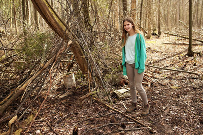 Full length of woman standing in forest