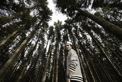 Low angle view of woman standing in forest