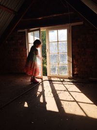 Girl standing by window at home