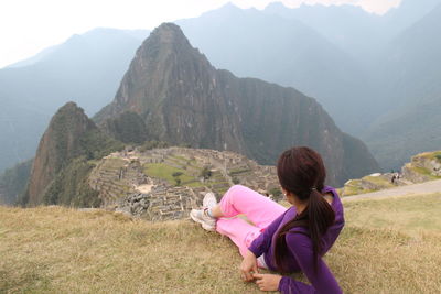 Rear view of woman on mountains against sky