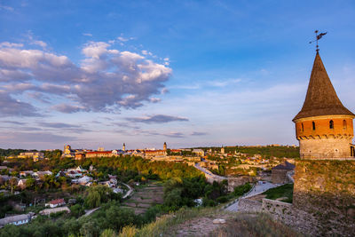 View of bell tower in town against cloudy sky