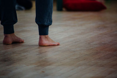 Low section of man standing on wooden floor