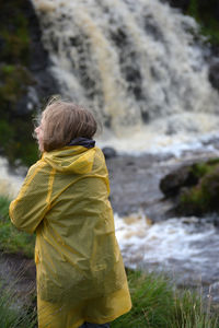 Rear view of woman looking at waterfall