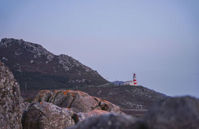 Lighthouse on mountain against clear sky
