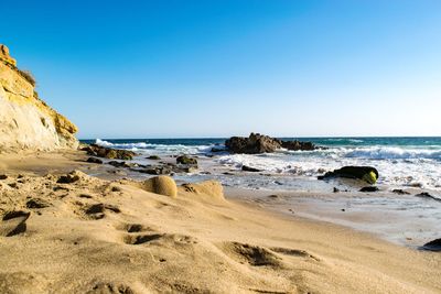 View of calm beach against clear sky