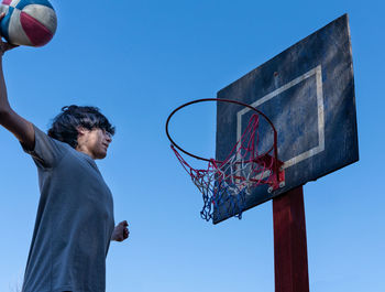 Low angle view of basketball hoop against blue sky