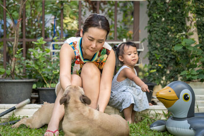 People with dog and inflatable raft while sitting on grass