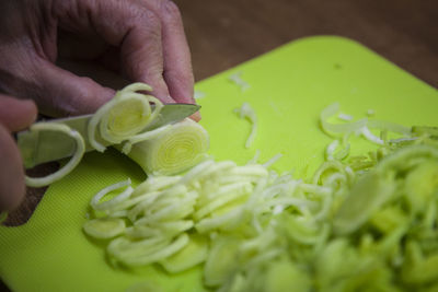 Cropped hand chopping leek