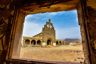 Temple against sky seen through window