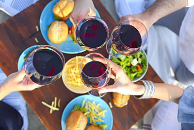 Cropped hands of people holding wineglass