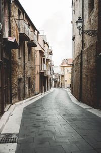 Empty alley amidst buildings in city