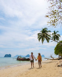 People at beach against sky