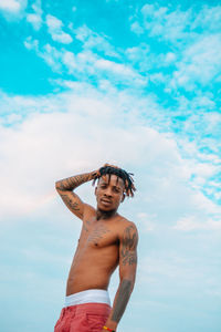 Portrait of smiling young man standing against sky