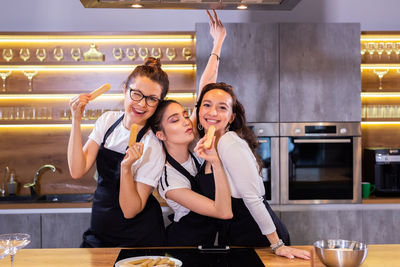 Portrait of smiling friends working at restaurant