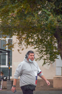 Full length of man standing against trees in city