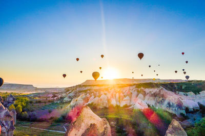 Hot air balloons flying over cappadocia against clear sky