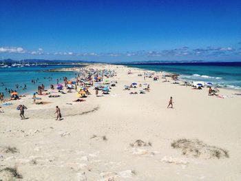 High angle view of people enjoying at beach against blue sky