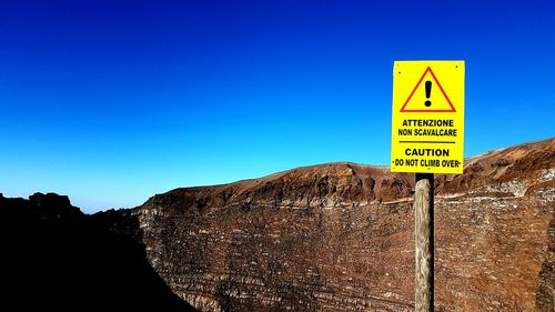 Information sign against clear blue sky