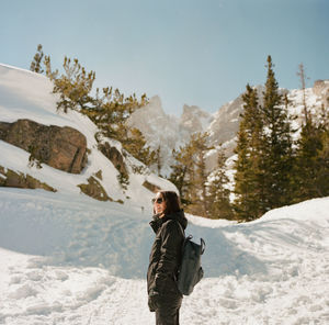 Side view of woman standing on snow covered mountain