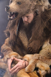 A bearded shaman is sitting dressed in skins, looking thoughtfully aside. magic in business