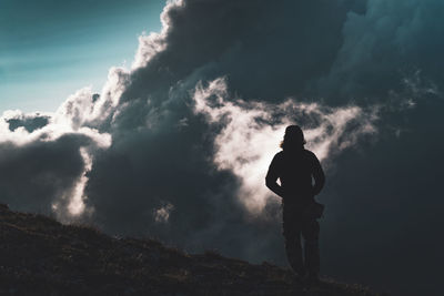 Rear view of silhouette man standing against sky