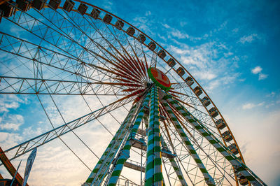 Low angle view of ferris wheel against cloudy sky