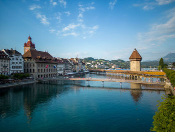 Buildings by river against sky