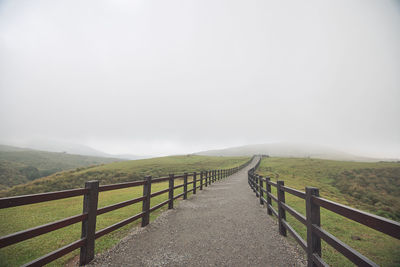 View of wooden fence on landscape against sky