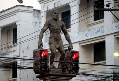 Low angle view of statue against building in city