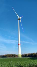 Low angle view of windmill on field against sky