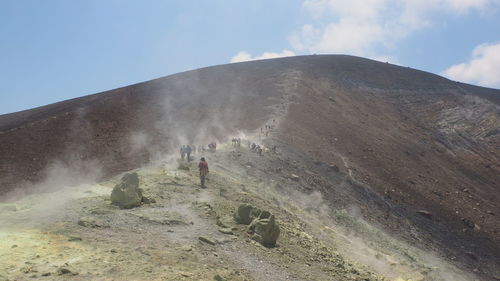 People hiking on mountain during foggy weather