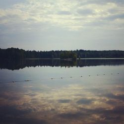 Scenic view of calm lake against cloudy sky