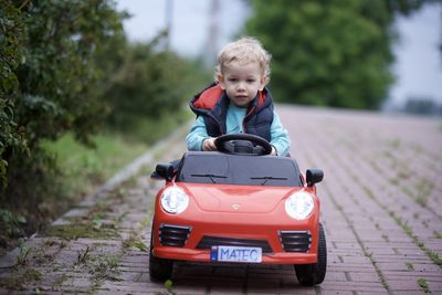 Portrait of boy holding car