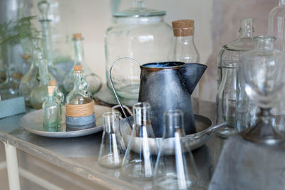 Empty chairs and table with glassware against wall at home