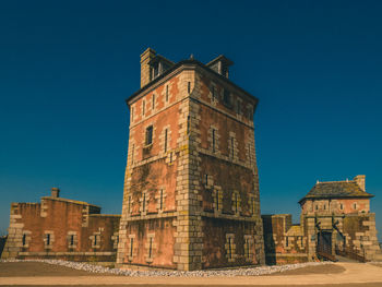 Low angle view of historical building against clear blue sky