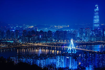 Illuminated cityscape against sky at night