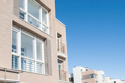 Low angle view of buildings against clear blue sky