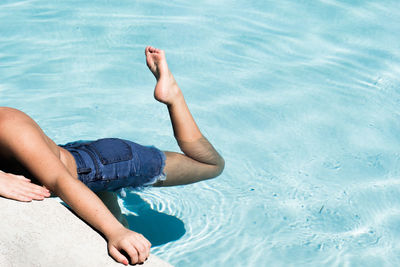 Low section of young woman in swimming pool