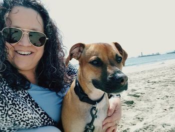 Portrait of young woman with dog on sunglasses