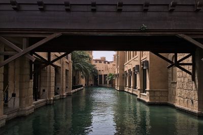 Bridge over river amidst buildings in city