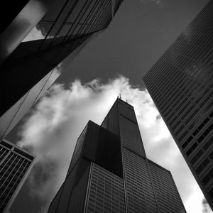 Low angle view of modern building against cloudy sky