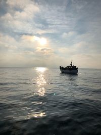Ship sailing on sea against sky during sunset