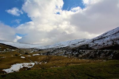 Scenic view of mountains against cloudy sky