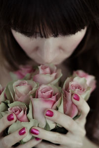 Close-up of hand holding pink roses