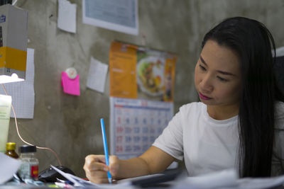 Woman looking at camera while sitting on table