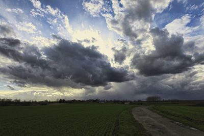 Scenic view of field against cloudy sky
