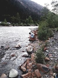 High angle view of people on rock in river